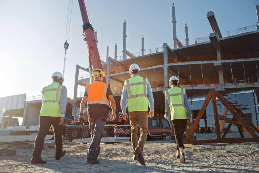 Construction team in full PPE walking across a live site