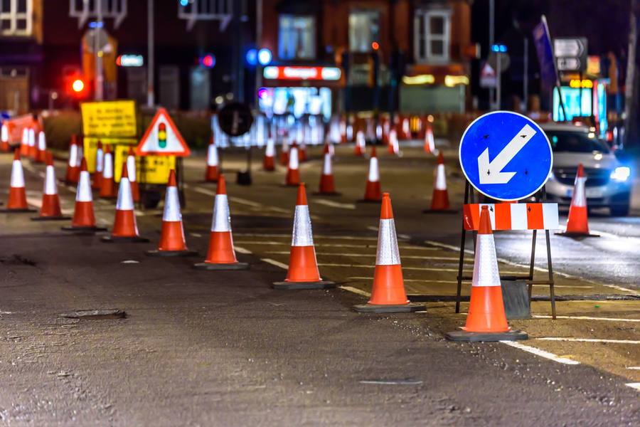 Night-time street works with cones and directional signage